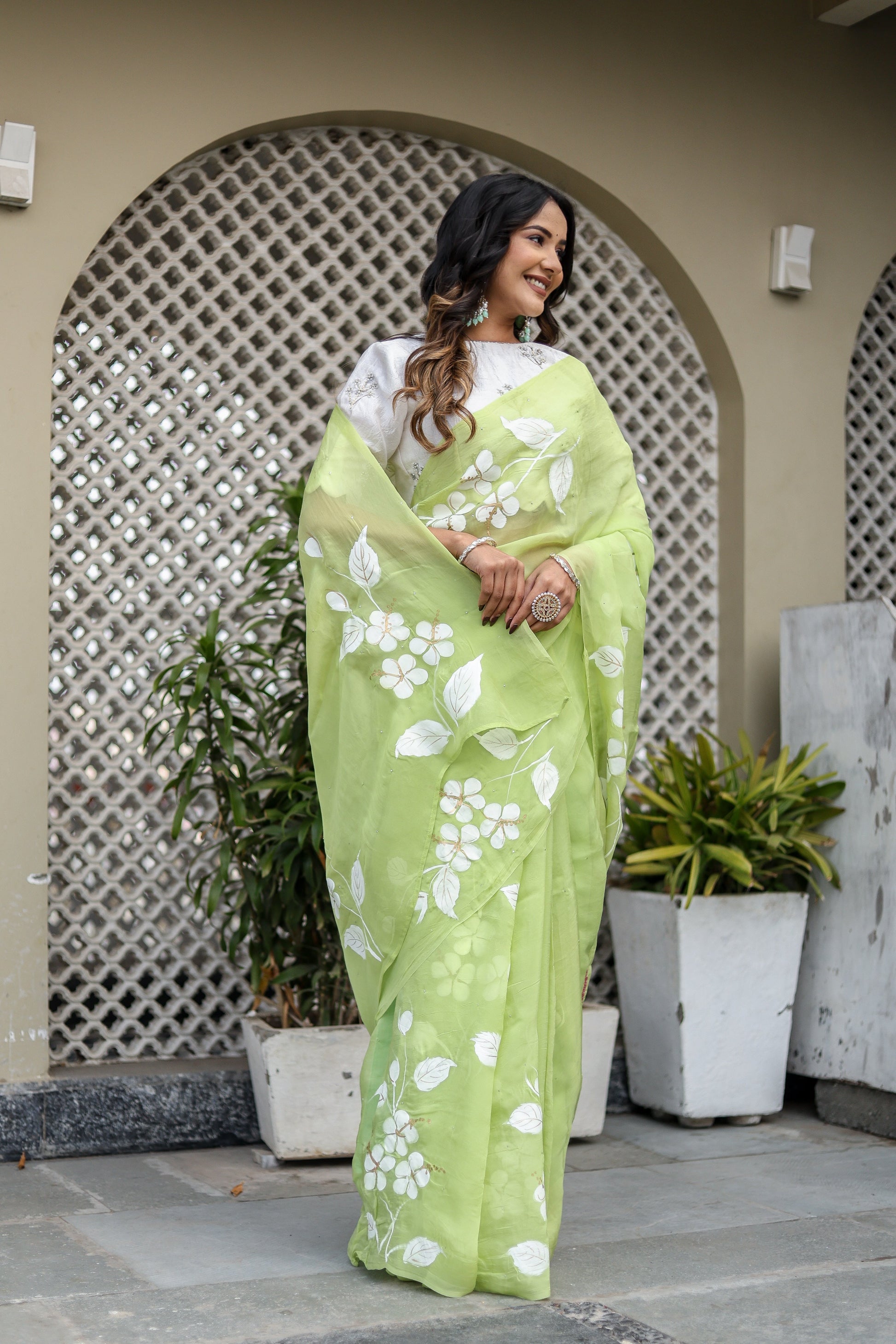 Lightweight party wear saree in green with floral embroidery, complemented by a stylish blouse