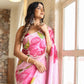 Lightweight party wear saree in pink with floral design, elegantly worn by a model near a window