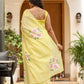 Women in a yellow lightweight party wear saree with floral embroidery and tassel details