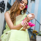 Model wearing a lightweight pastel saree with floral print, accessorized with jewelry and flowers in her hair