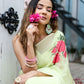 Model wearing a lightweight pastel saree with floral print, paired with jewelry and accessories
