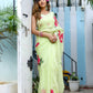 Model wearing a lightweight pastel saree with floral print standing by a staircase surrounded by greenery