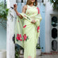 Elegant lightweight pastel saree with floral print, featuring pink flowers against a soft green background.