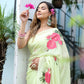 Model wearing a lightweight pastel saree with floral print, styled with accessories and flowers in hair