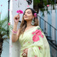 Lightweight pastel saree with floral print worn elegantly by a woman, surrounded by pink flower petals