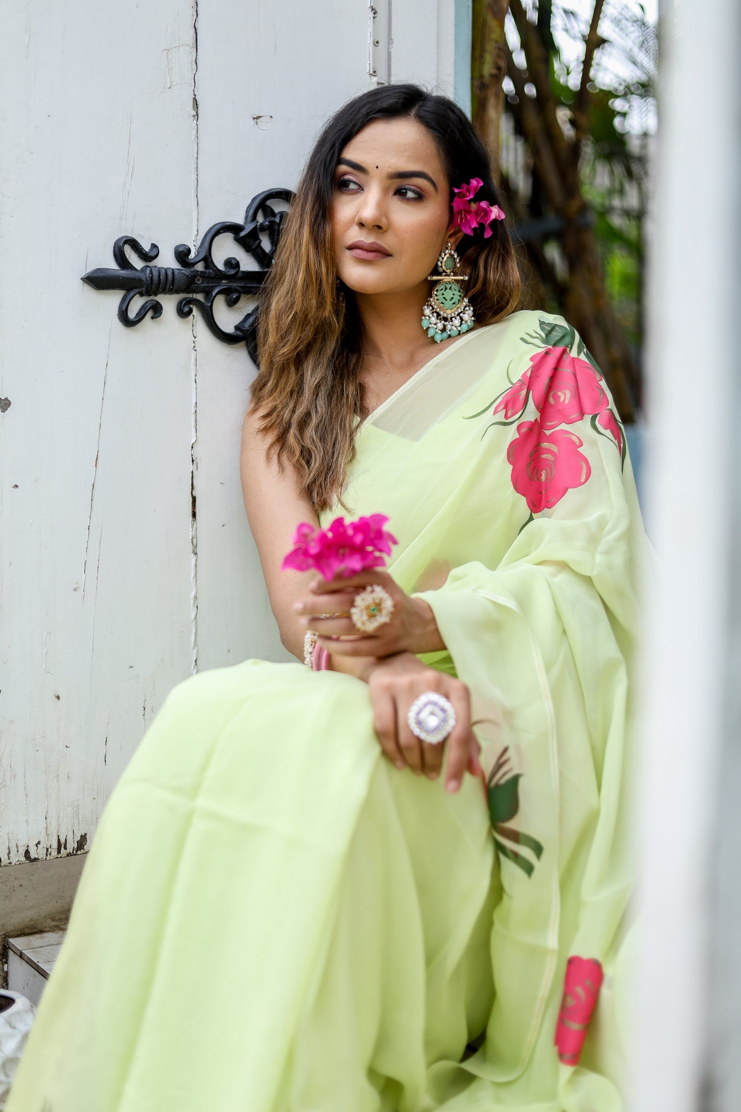 Elegant model wearing a lightweight pastel saree with floral print, styled with floral accessories
