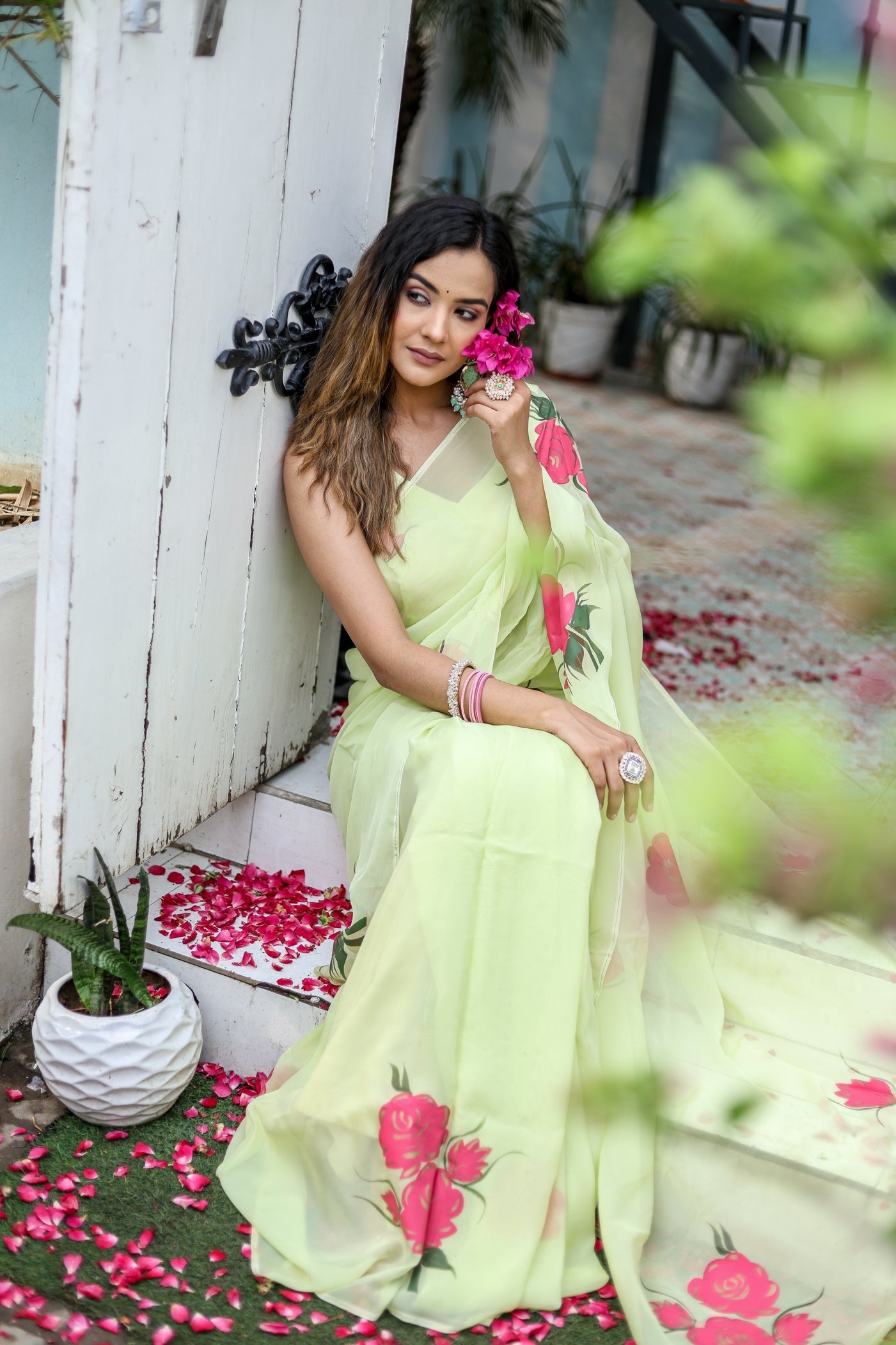 Elegant lightweight pastel saree with floral print styled with accessories and rose petals