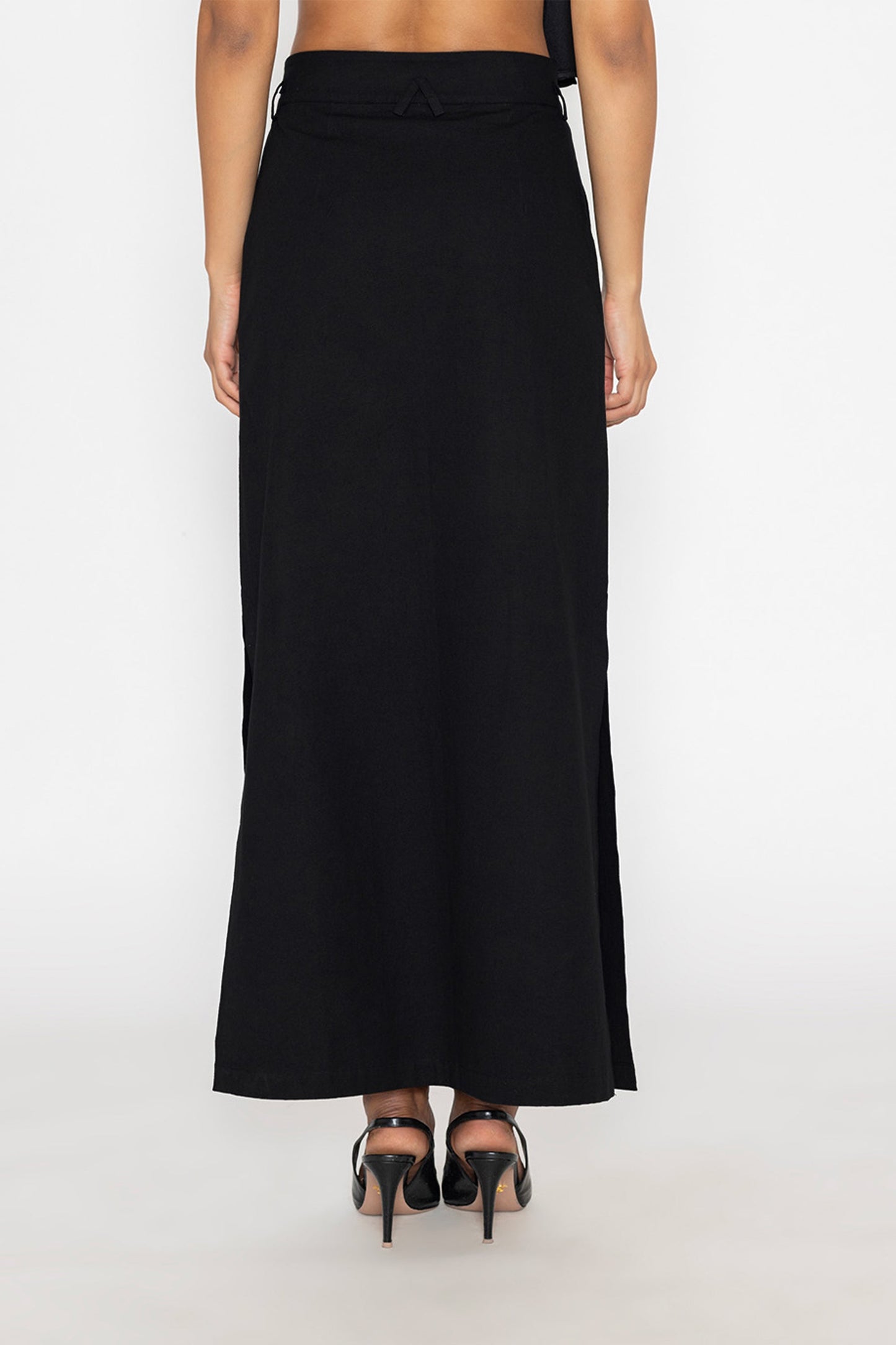 Stylera long black skirt with slit shown from the back with high heels