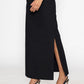 Woman wearing a long black skirt with slit from Stylera paired with black pointed heels