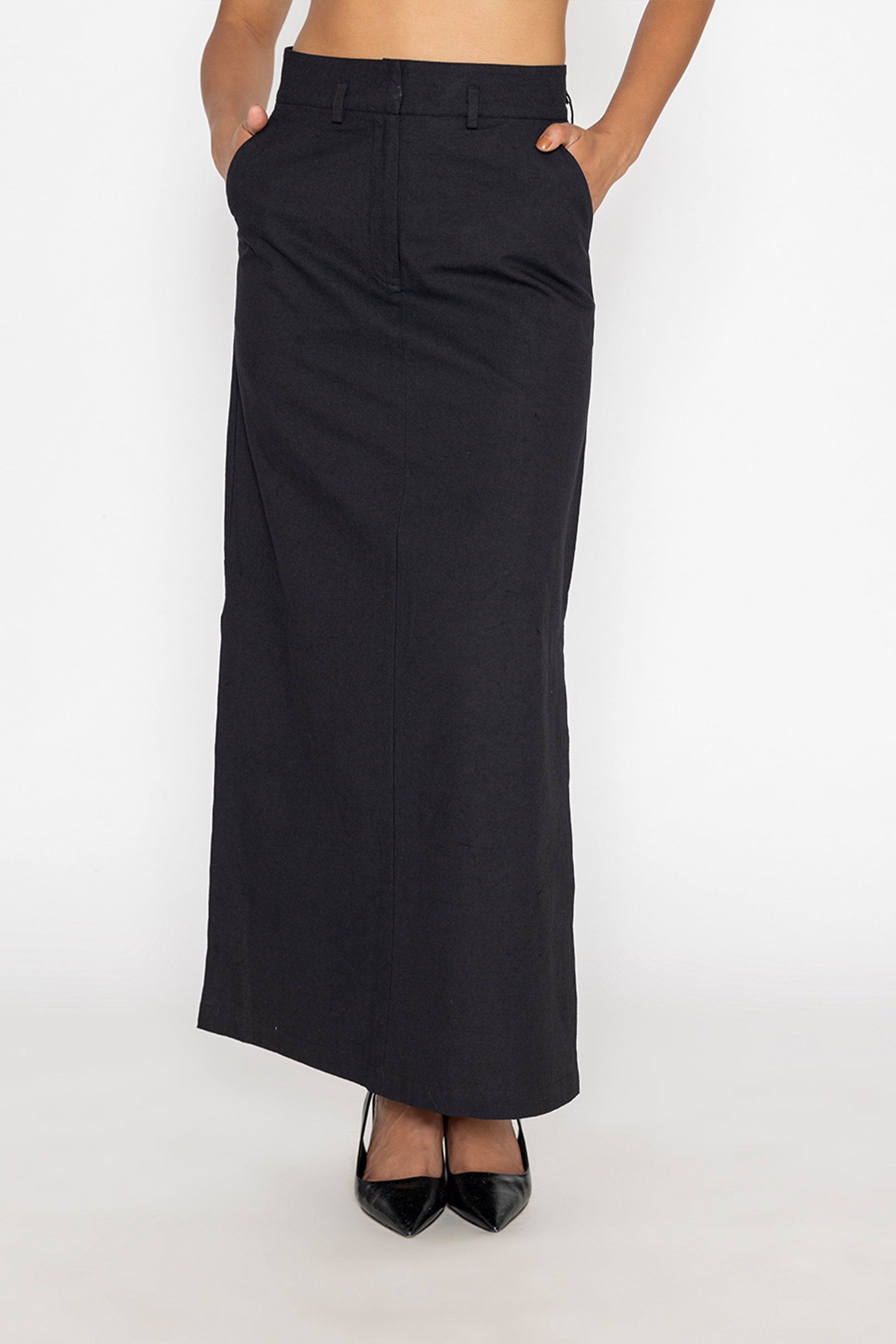 Stylera long black skirt with slit paired with black pointed heels