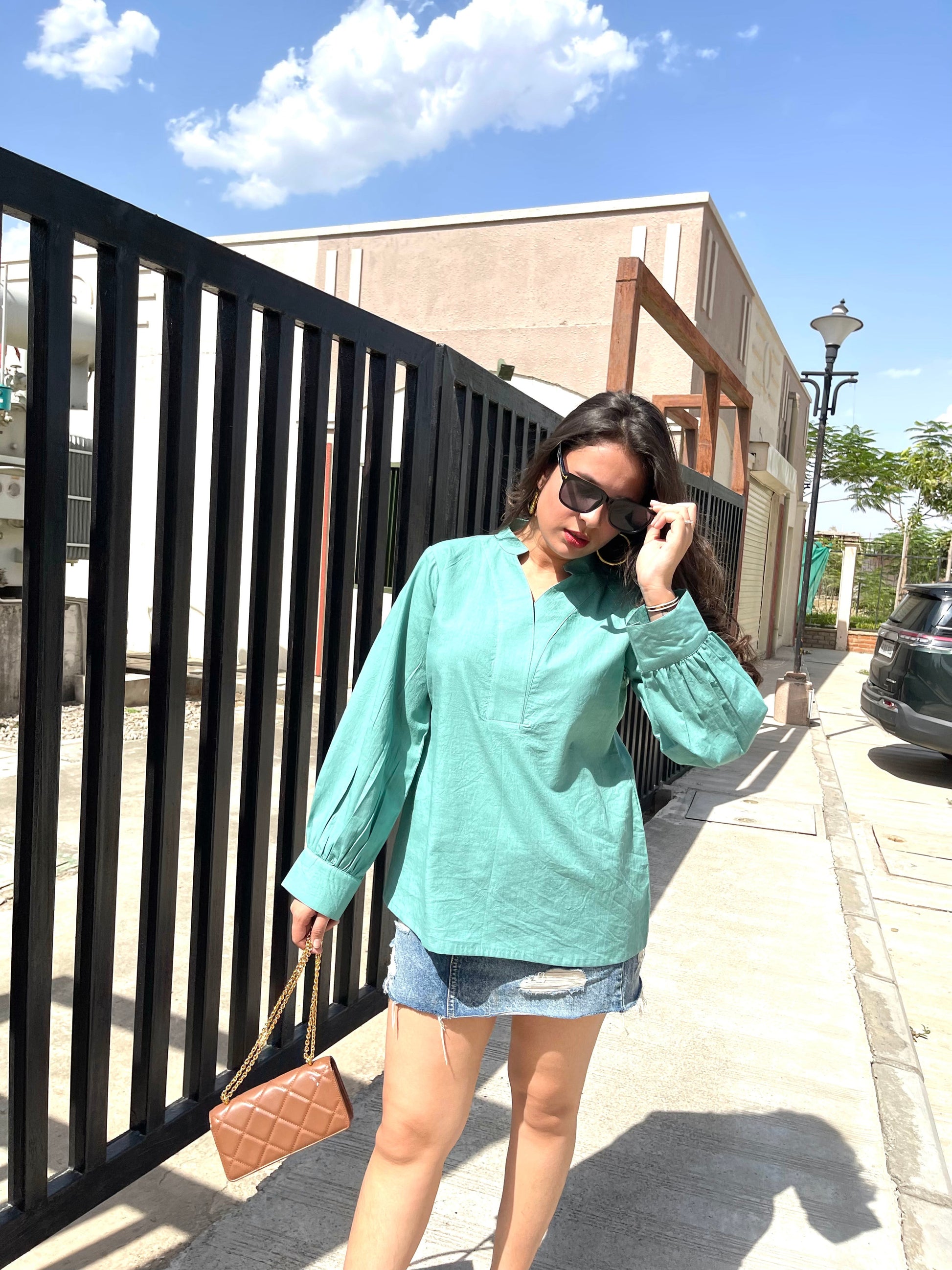 Woman wearing a long sleeve lightweight top for women in turquoise with relaxed fit and stylish sunglasses