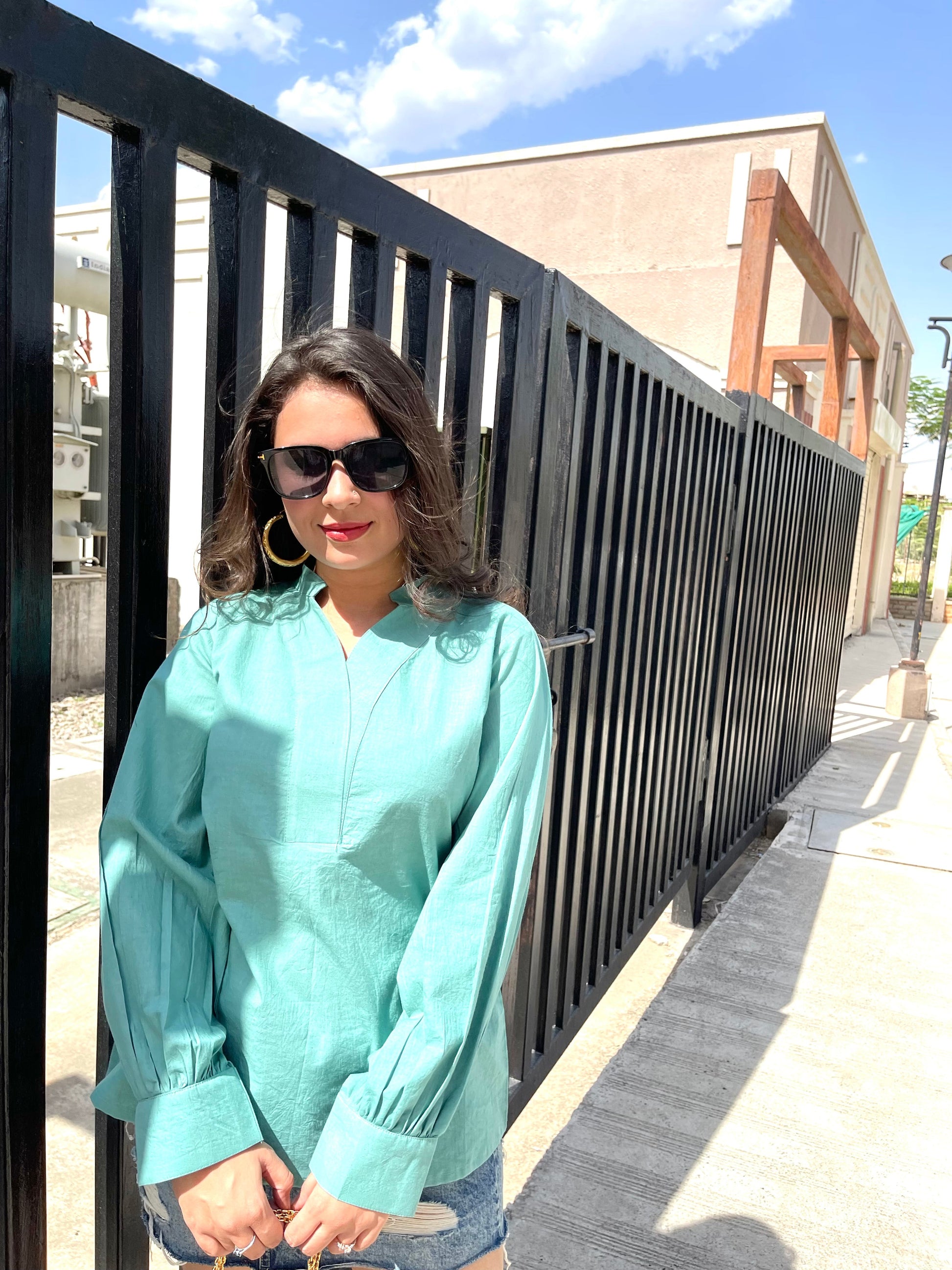 Stylera long sleeve lightweight top for women in teal, styled with sunglasses and casual shorts