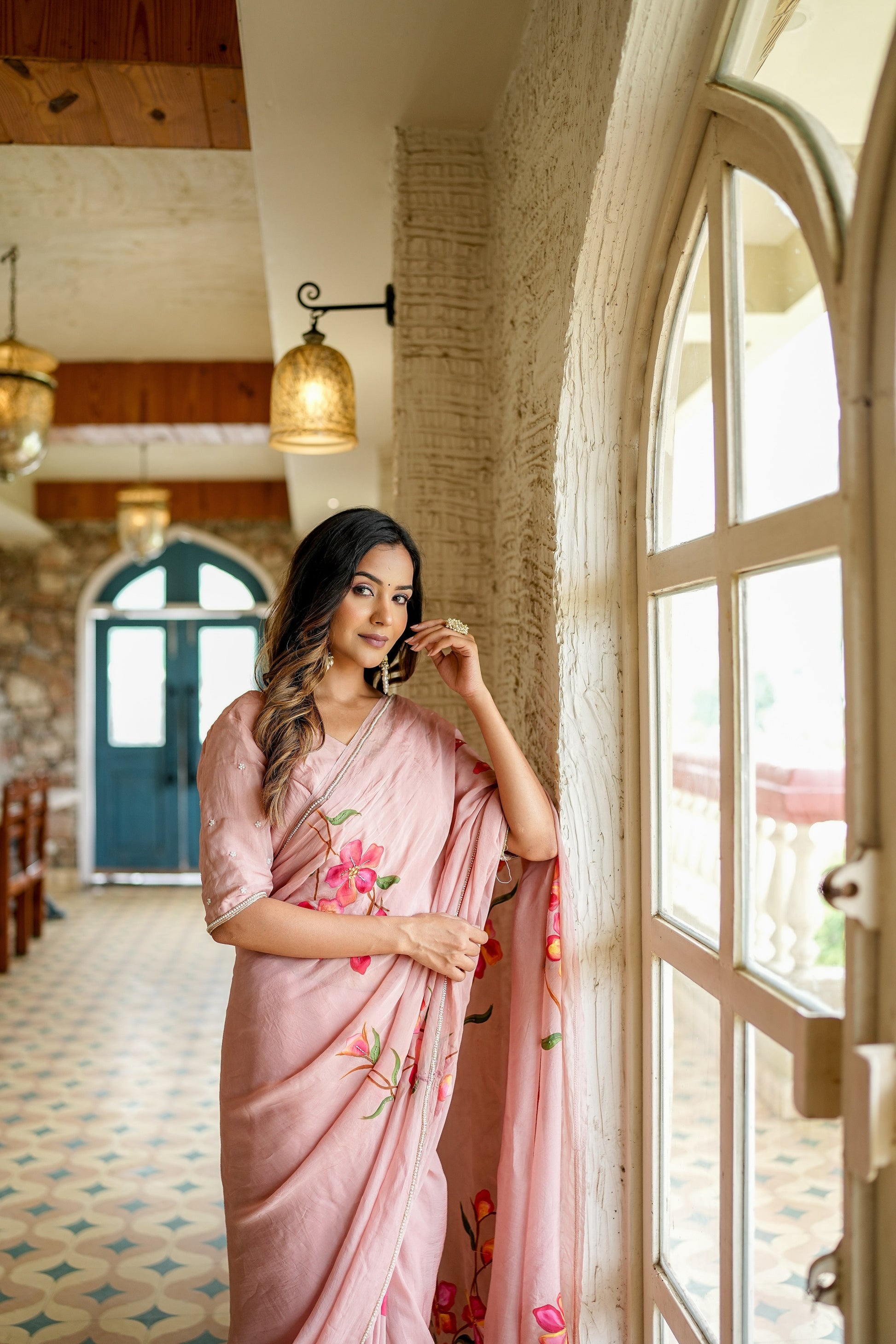 Elegant woman in a pink luxury statement saree for special occasions, adorned with floral embroidery