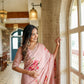 Elegant luxury statement saree for special occasions with floral embroidery, worn by a woman by the window