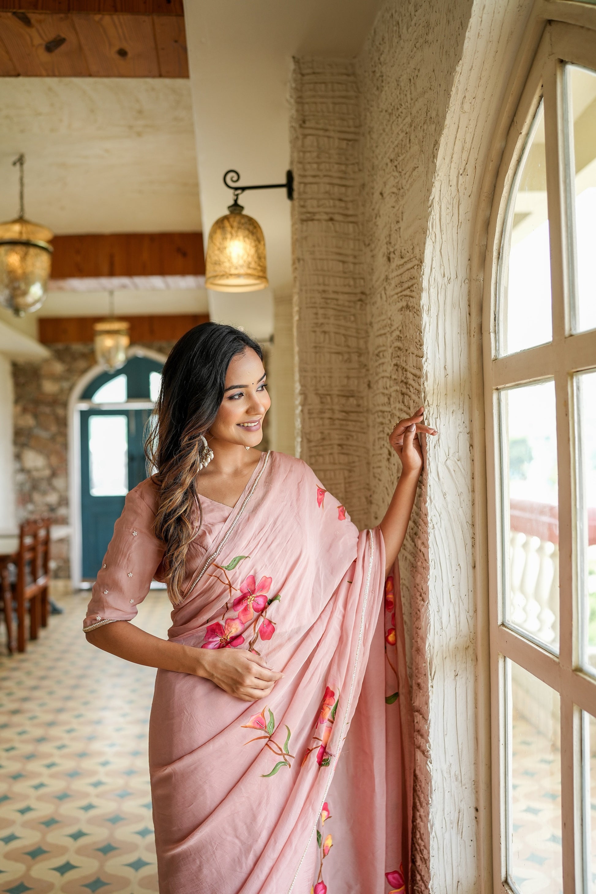 Elegant luxury statement saree for special occasions with floral embroidery, worn by a woman by the window