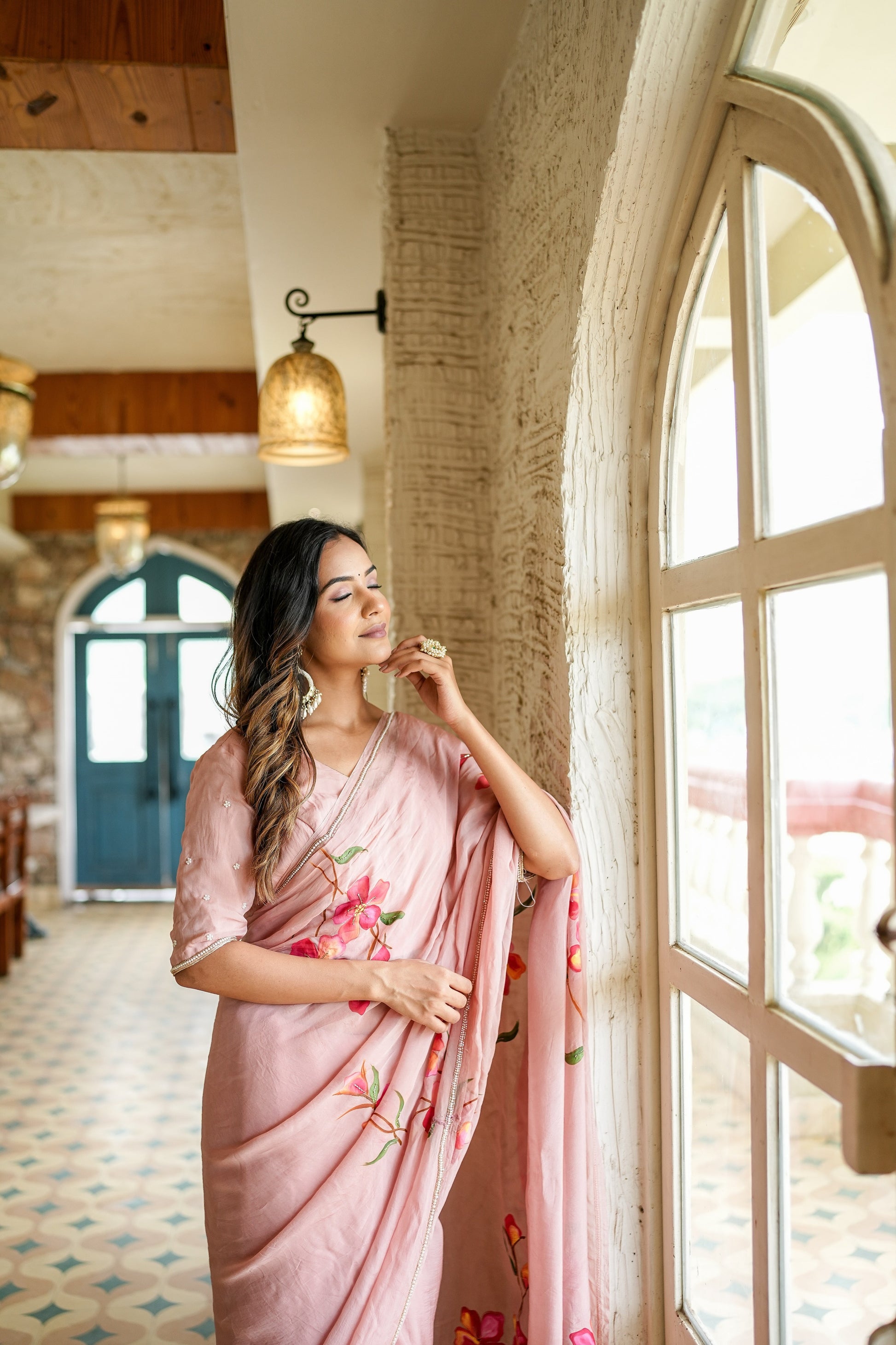 Elegant woman in a pink luxury statement saree for special occasions, featuring floral embroidery