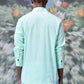 Male model back view wearing mint malmal regular fit formal shirt with long sleeves and casual striped pants