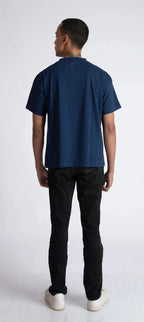 Back view of a man wearing Stylera men's blue regular fit t-shirt with black pants and white shoes