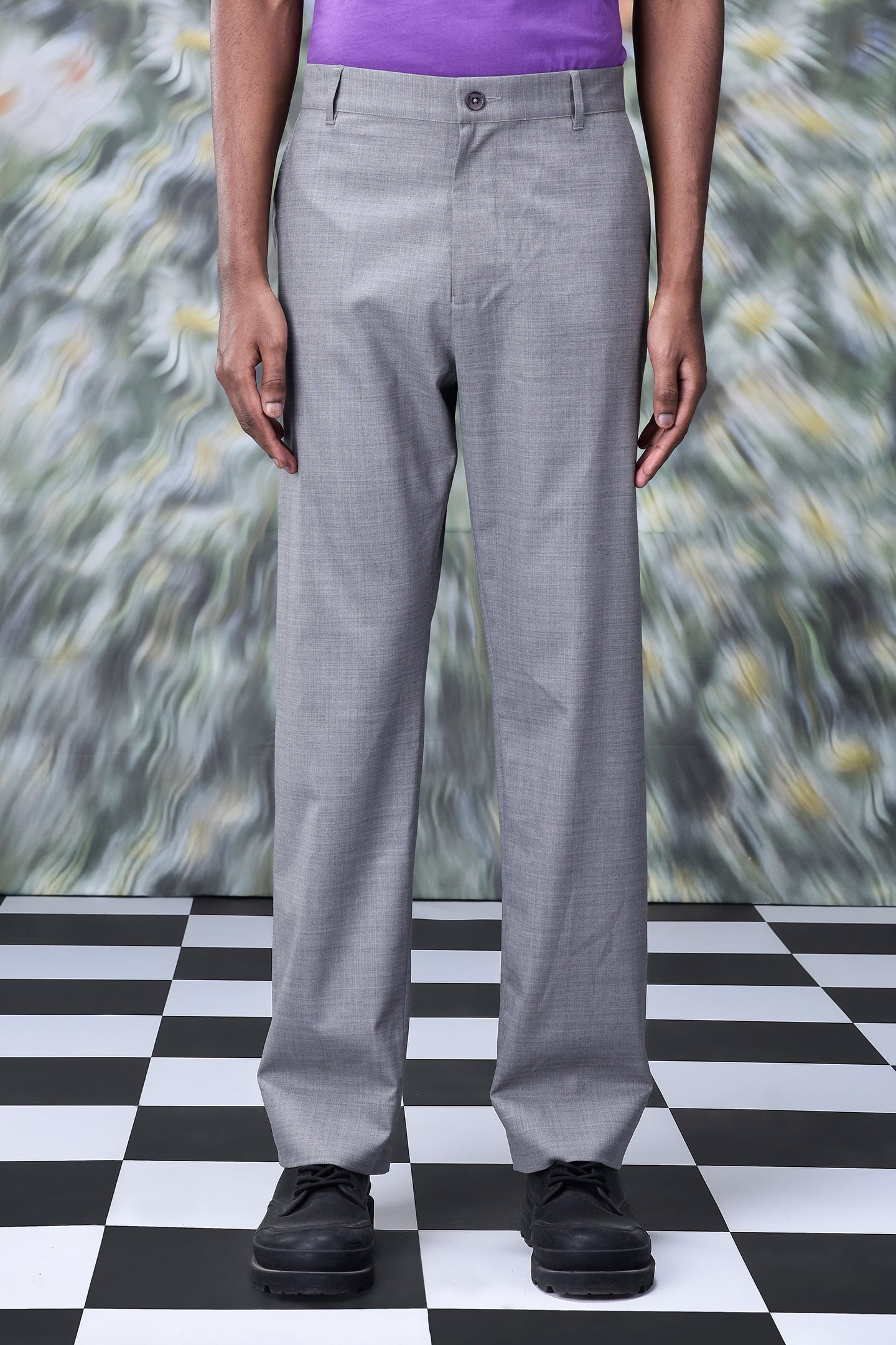 Grey men's business casual trousers by Stylera worn with black shoes on checkered floor