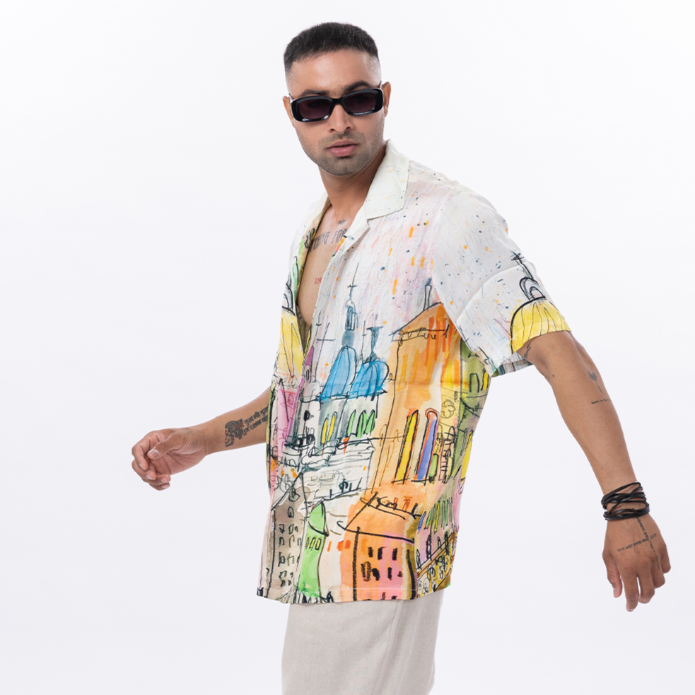 Stylera men's casual graphic shirt featuring a vibrant artistic design with cityscapes and colorful patterns