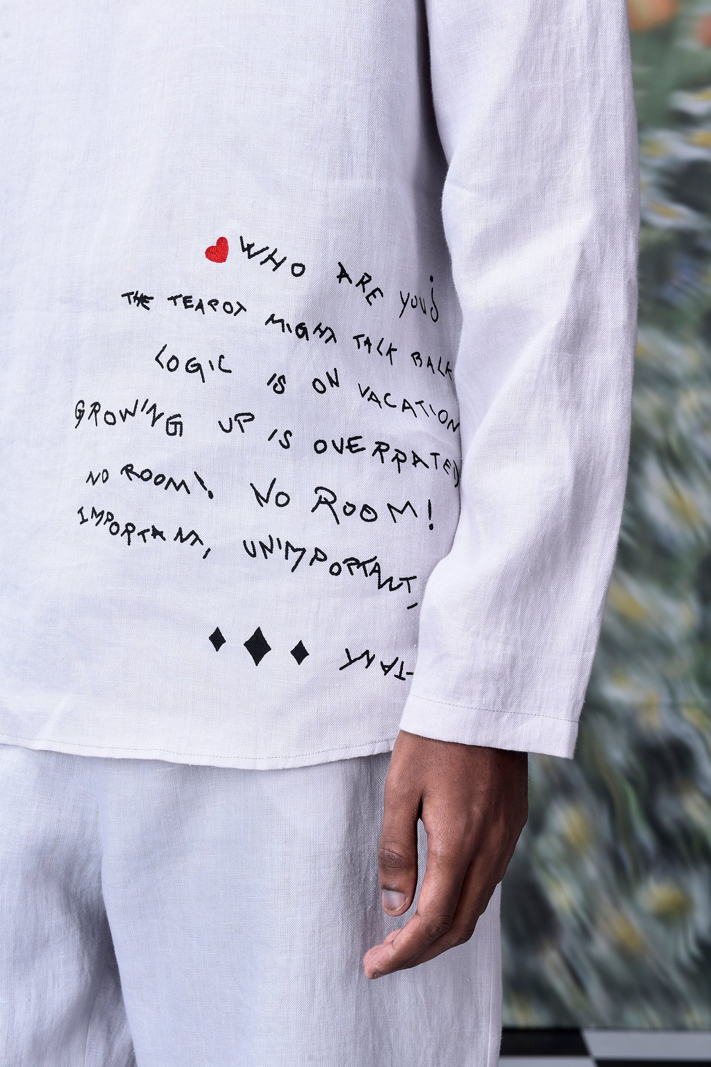 Close-up of Stylera mens linen statement shirt with black handwritten text design on white fabric