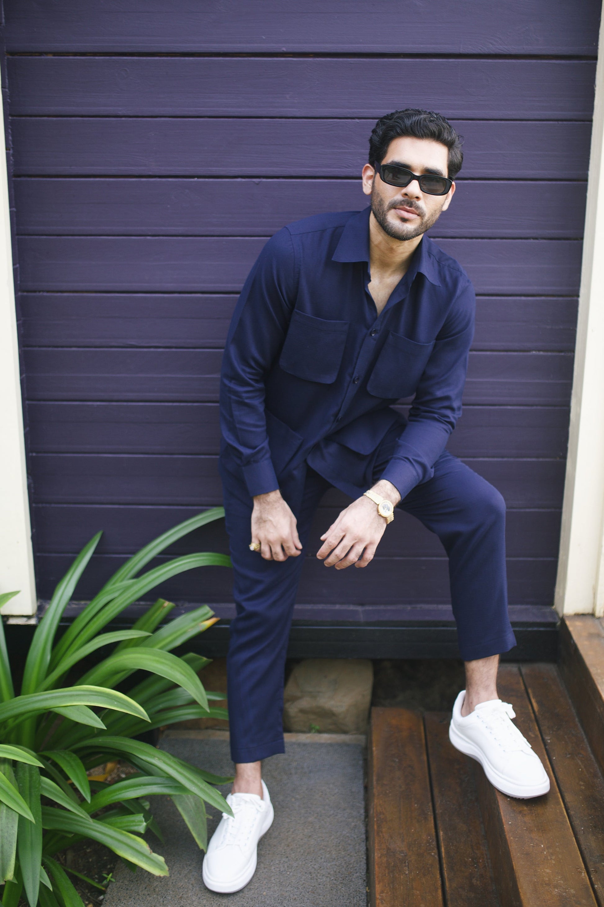 Men's matching outfit set in navy featuring a button-up shirt and tailored pants, styled with sunglasses