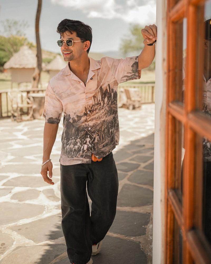 Stylera model wearing men's printed casual button up shirt with scenic vintage print short sleeves and sunglasses