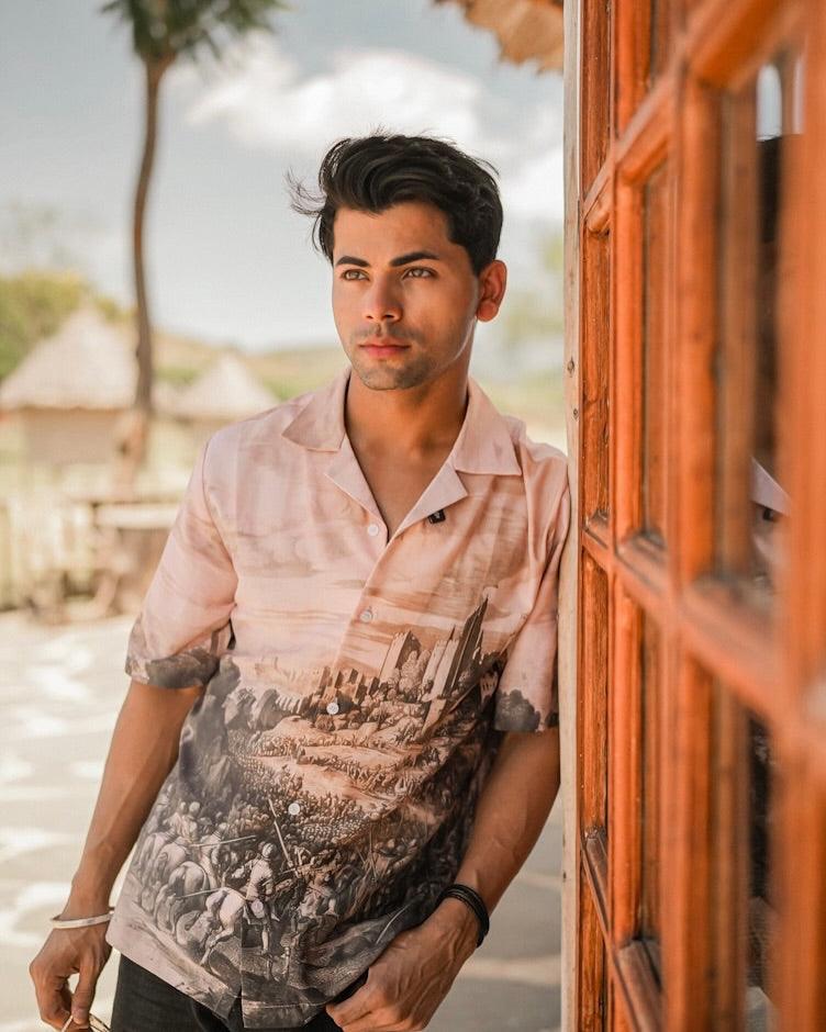 Stylera men's printed casual button up shirt in beige with cityscape print worn by model leaning on wooden door