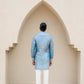 Men's printed kurta with butterfly design in blue fabric, styled with white trousers