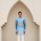 Men's printed kurta with butterfly design in light blue, worn with white trousers for a stylish look