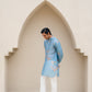 Men's printed kurta with butterfly design in soft blue, styled with white pants and sandals