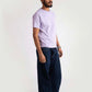 Model wearing Stylera men's regular fit lavender tee paired with dark wide-leg pants and white sneakers
