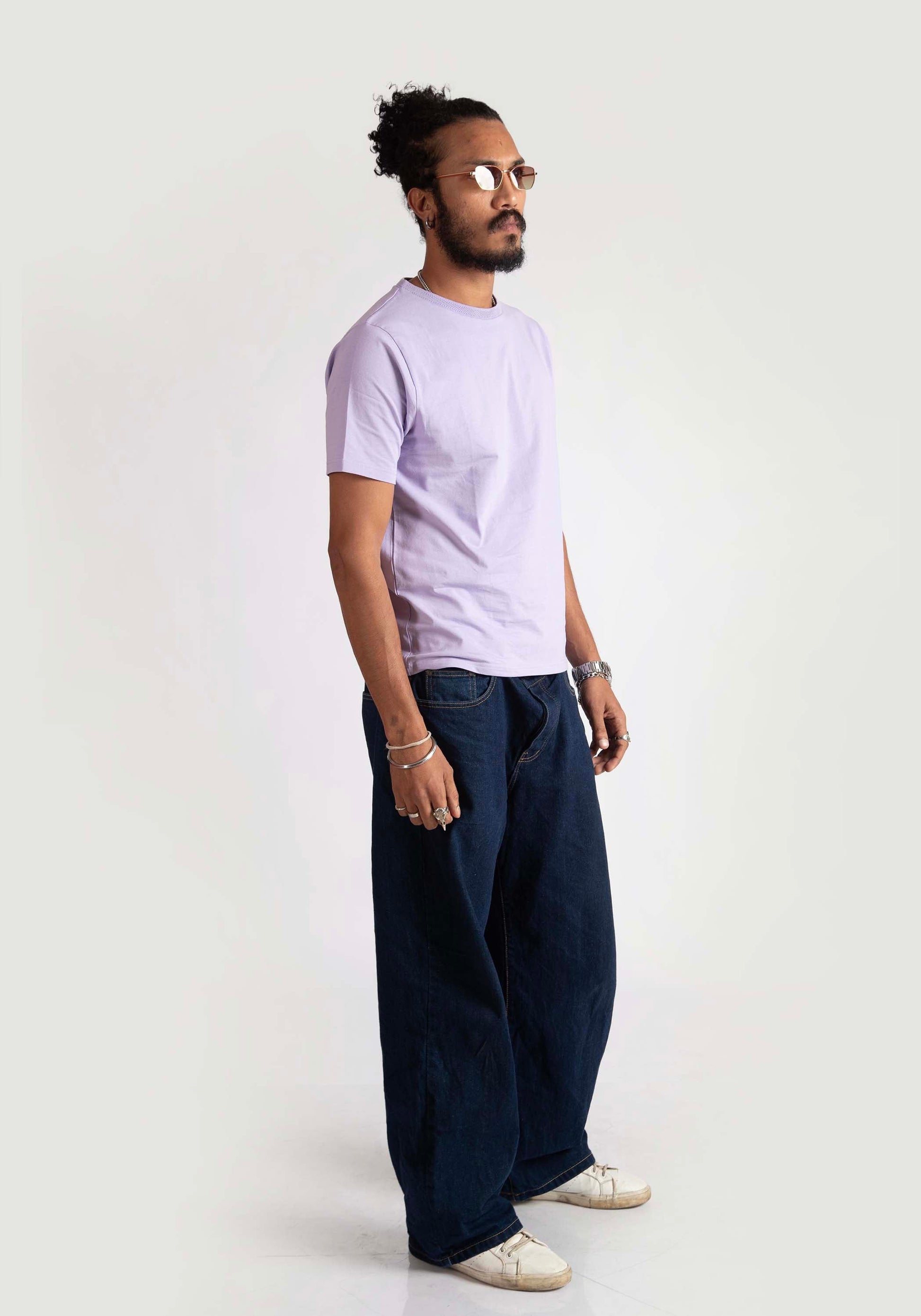 Model wearing Stylera men's regular fit lavender tee paired with dark wide-leg pants and white sneakers