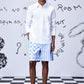 Men's trendy white shirt by Stylera worn with blue and white patterned shorts