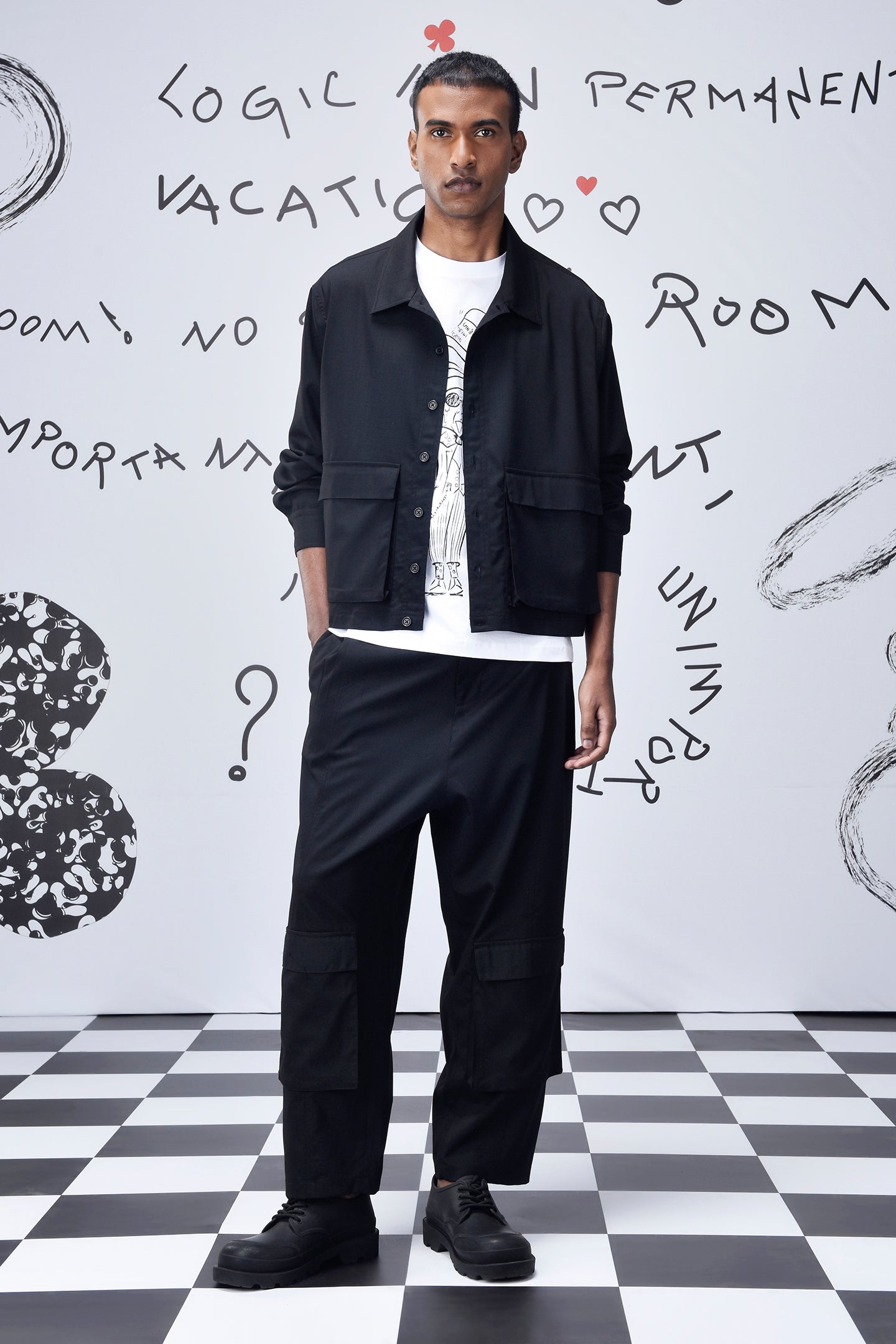 Stylera model wearing black casual jacket men's with white graphic tee black cargo pants and sneakers