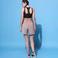 Back view of metallic tie-up shorts for women paired with a black crop top and stylish sneakers