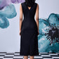 Back view of model wearing Stylera midi black dress with belt sleeveless V back mid calf length