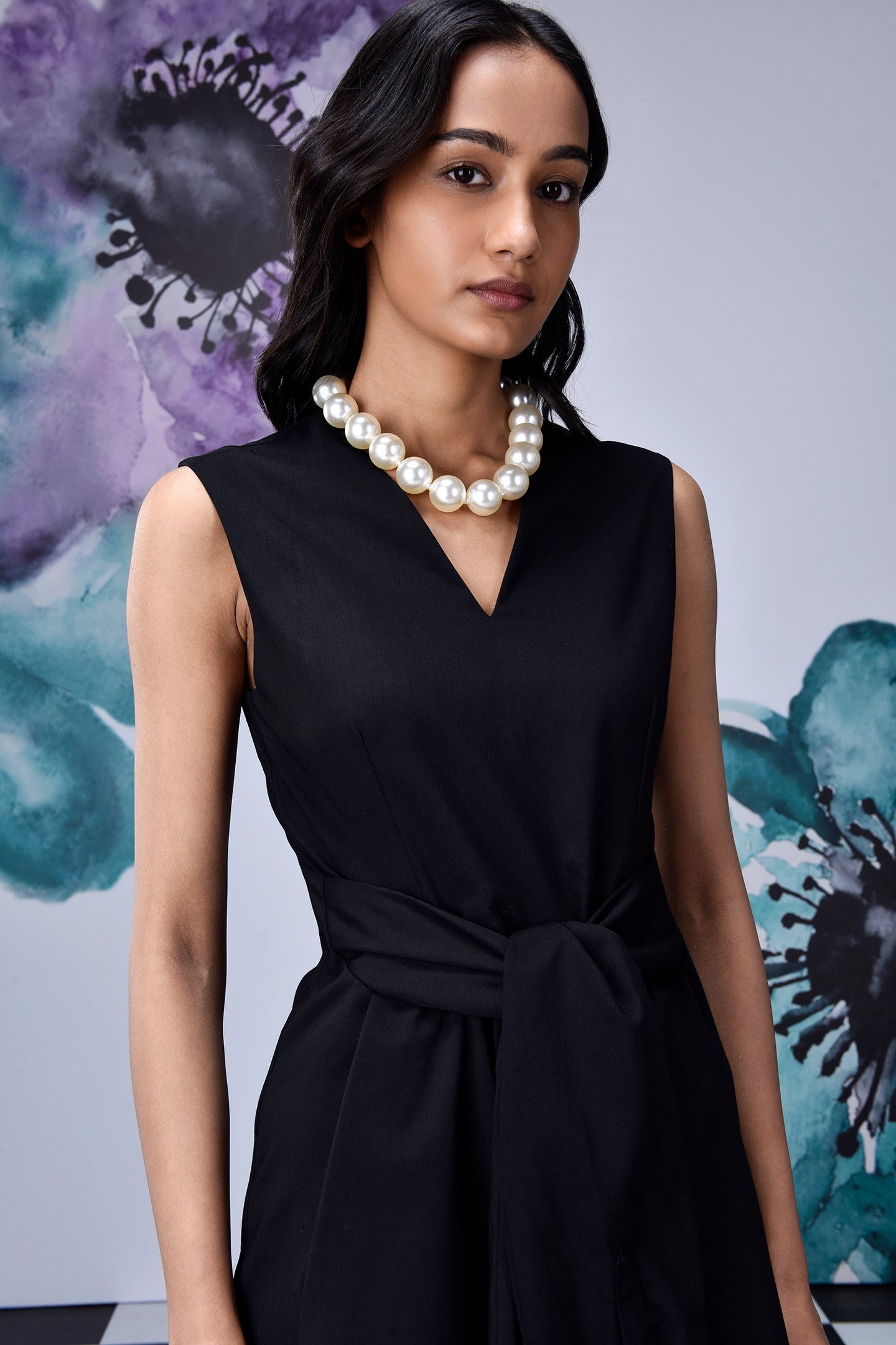 Stylera midi black dress with belt sleeveless V neck model wearing pearl necklace