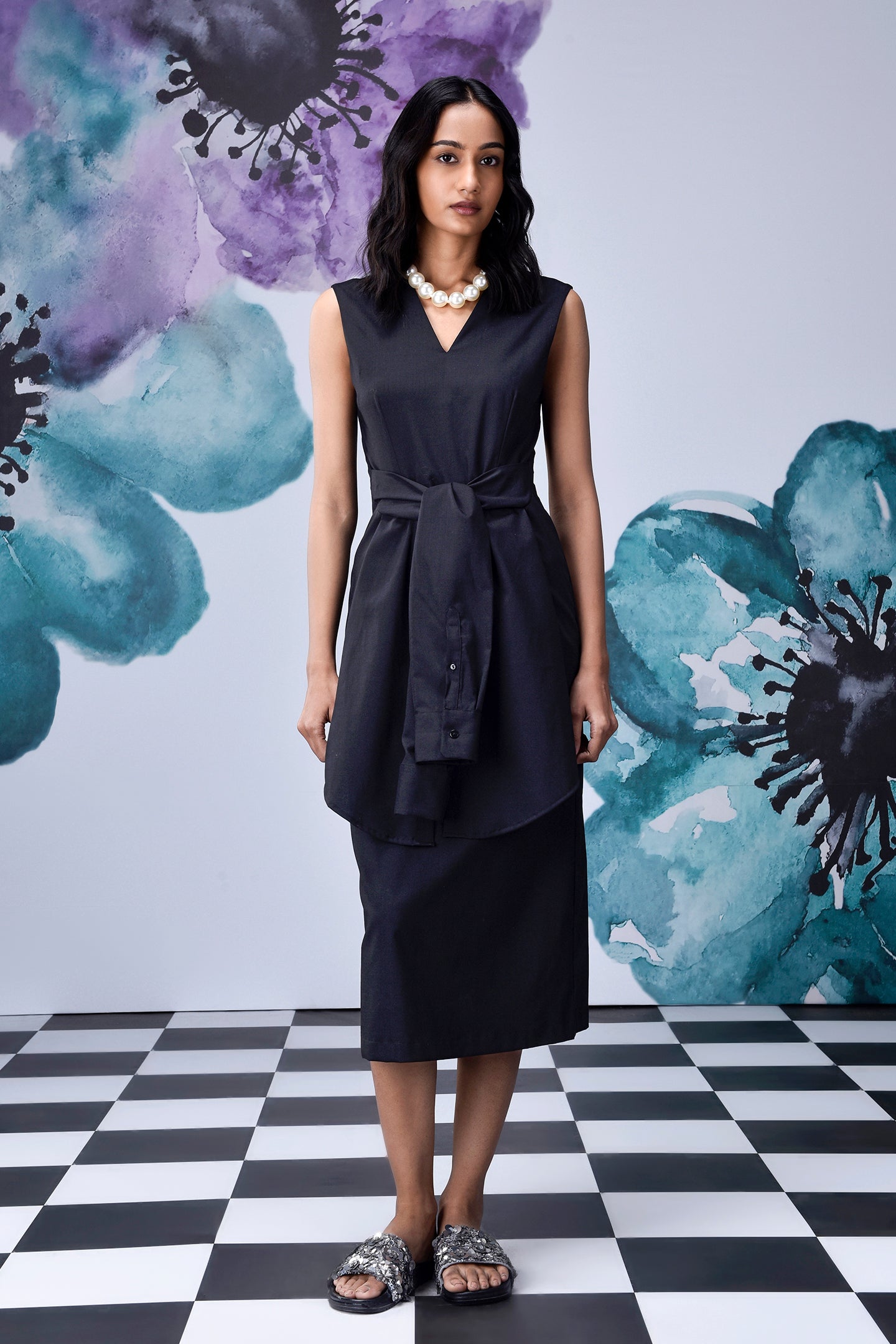 Stylera model wearing midi black dress with belt sleeveless V neck layered tunic