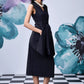 Stylera model wearing a sleeveless midi black dress with belt and side pockets