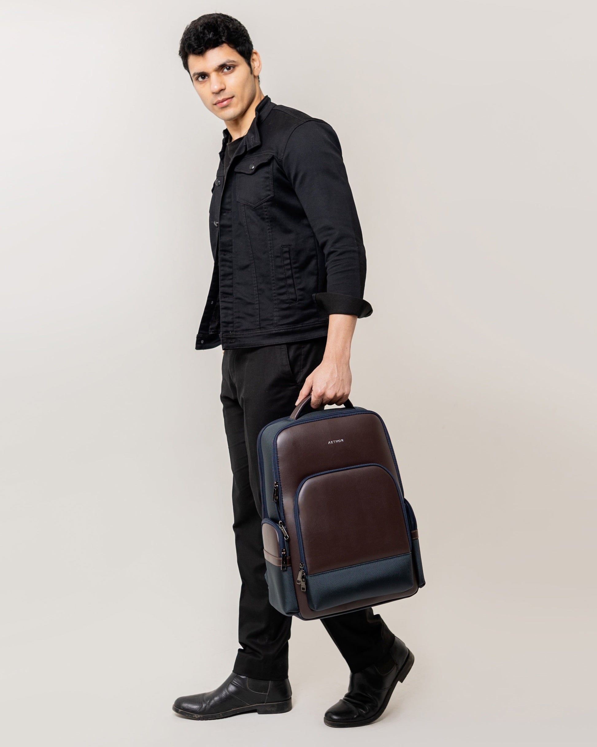 Stylera luxury mocha blue leather backpack carried by model with top handle and front pockets