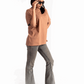 Woman wearing Stylera mocha brown oversized t-shirt paired with gray flared jeans and black platform shoes