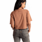 Stylera mocha oversized crop top worn by a woman shown from the back with gray jeans