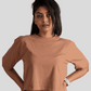 Woman wearing Stylera mocha oversized crop top paired with denim jeans against a plain background