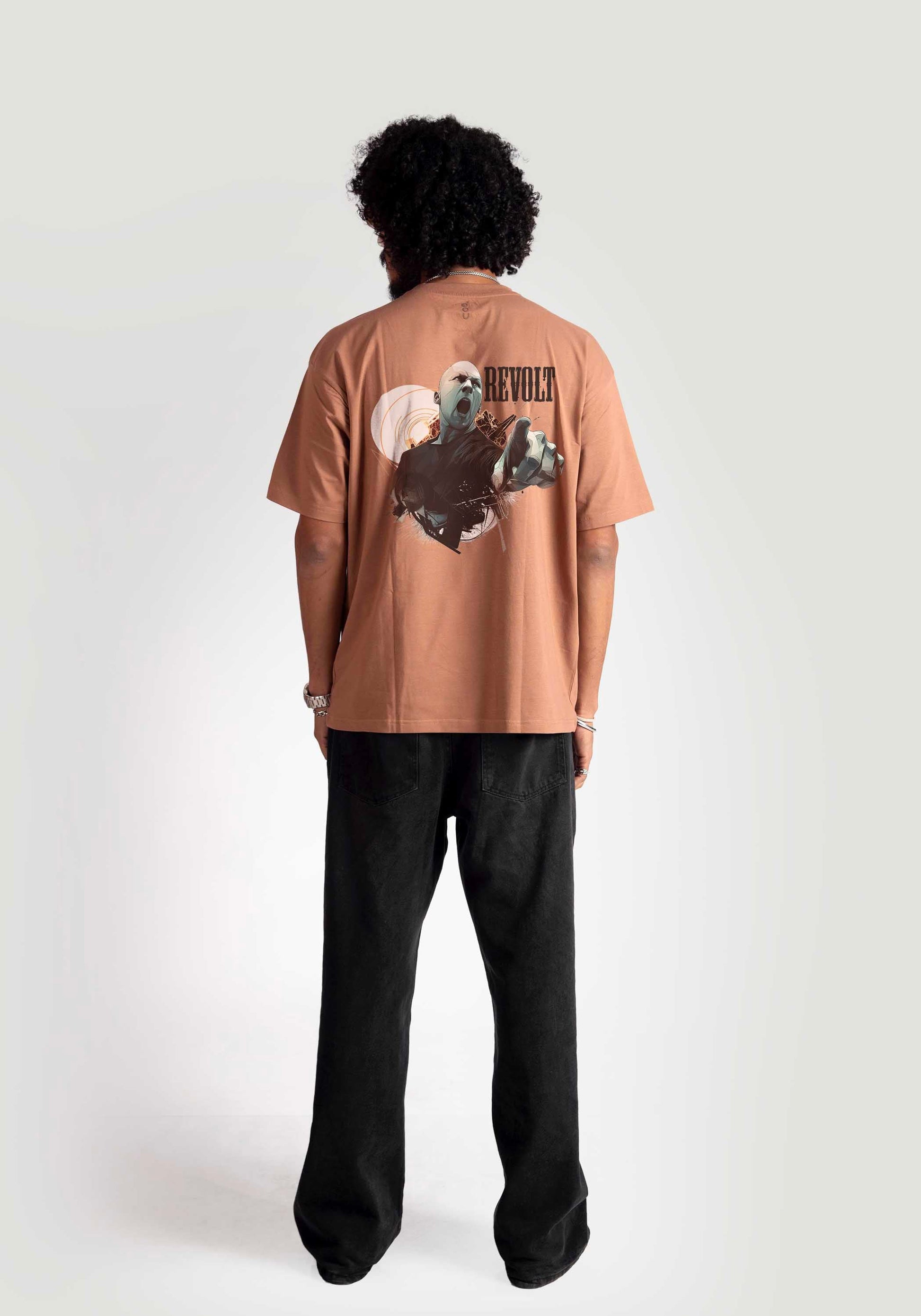 Back view of model wearing Stylera mocha oversized t-shirt with graphic design and black pants