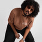 Man wearing mocha oversized t-shirt with white print paired with black pants and sunglasses