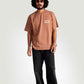 Man wearing mocha oversized t-shirt from Stylera paired with black pants and white sneakers