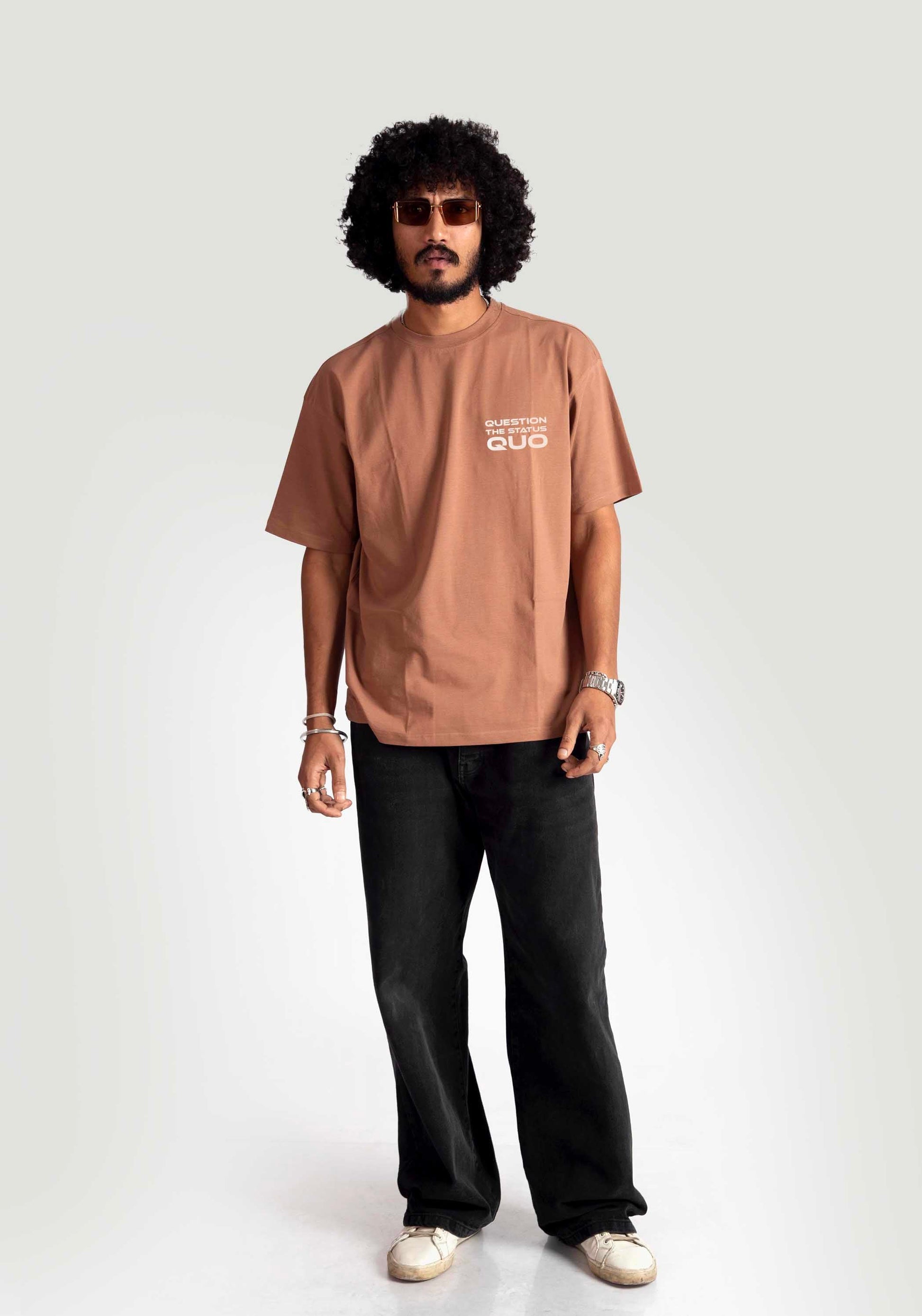 Man wearing mocha oversized t-shirt from Stylera paired with black pants and white sneakers