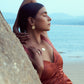 Stylera model wearing modern gold fashion earrings round disc with matching pendant by the beach
