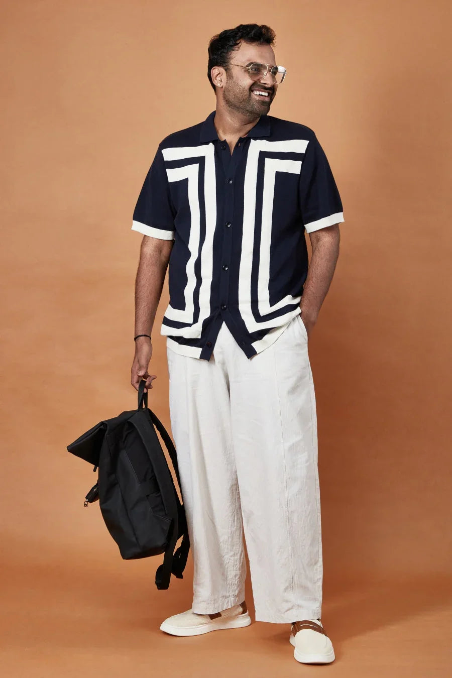 Stylish modern short sleeve polo shirt for men in navy with geometric design, paired with light trousers